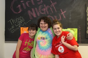 Three teen girls hugging and smiling at Girls Night Out in Harford County. 