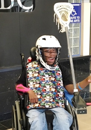 Kid using a wheelchair adapted so he can play lacrosse