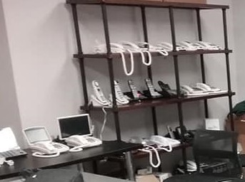 Shelf and table with a variety of telephones displayed
