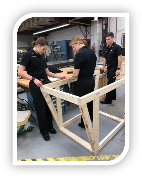 Team of engineering students working on wood frame for glider.