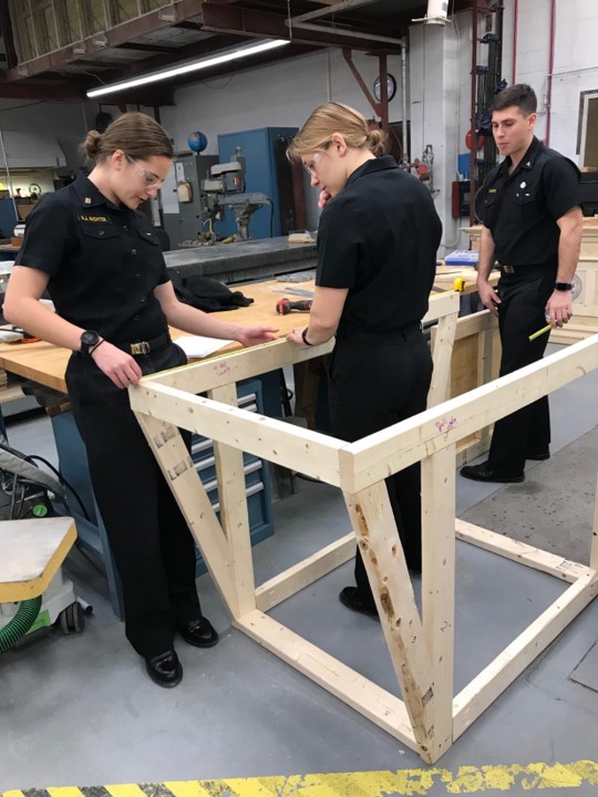 Three engineers from the United States Naval Academy building a product prototype.