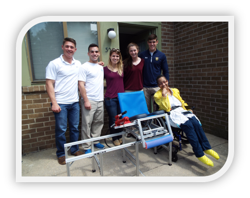 The 5 member engineering team with Nacole seated in her completed shower transfer device.