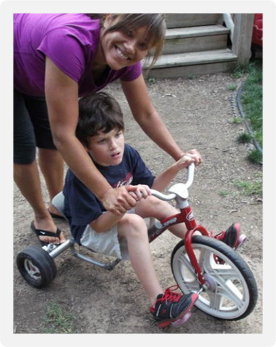 Colby on his toddler trike with his Mom.
