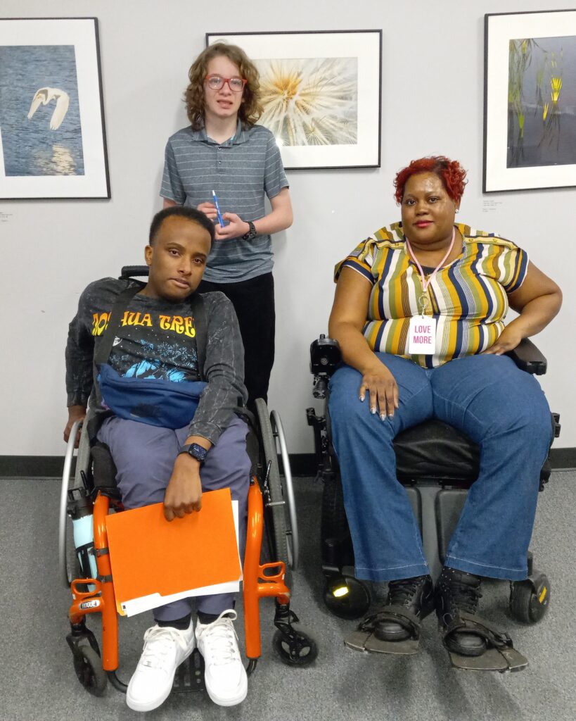 Connect Program Instructor Keyonna Mayo sits in her wheelchair along two Connect program students, one of which is also sitting in his wheelchair. 