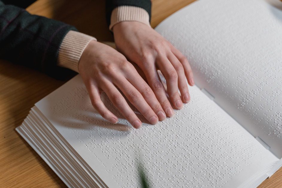 A Person Touching a Braille Book.