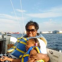 Women on a sailboat with her daughter smiling.